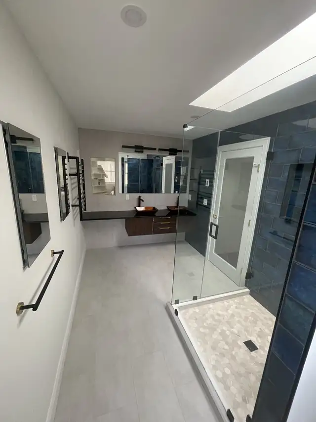 Rehoboth, MA bathroom with skylight, gray porcelain floor, black towel bar and glass walk-in shower